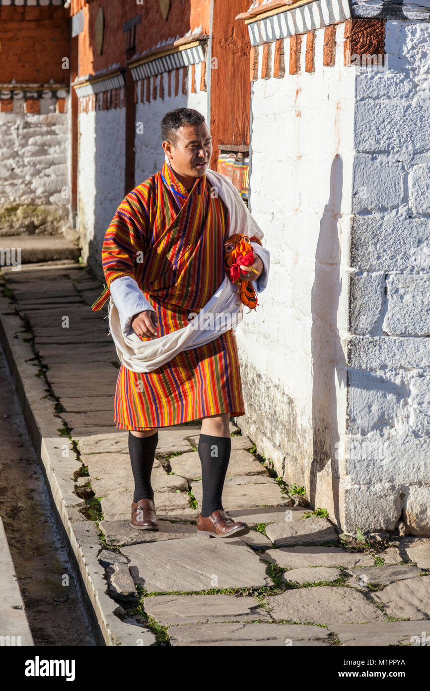 Bumthang, Bhutan.  Bhutanese Man Wearing Traditional Gho.  Jambay Lhakhang Monastery. Stock Photo