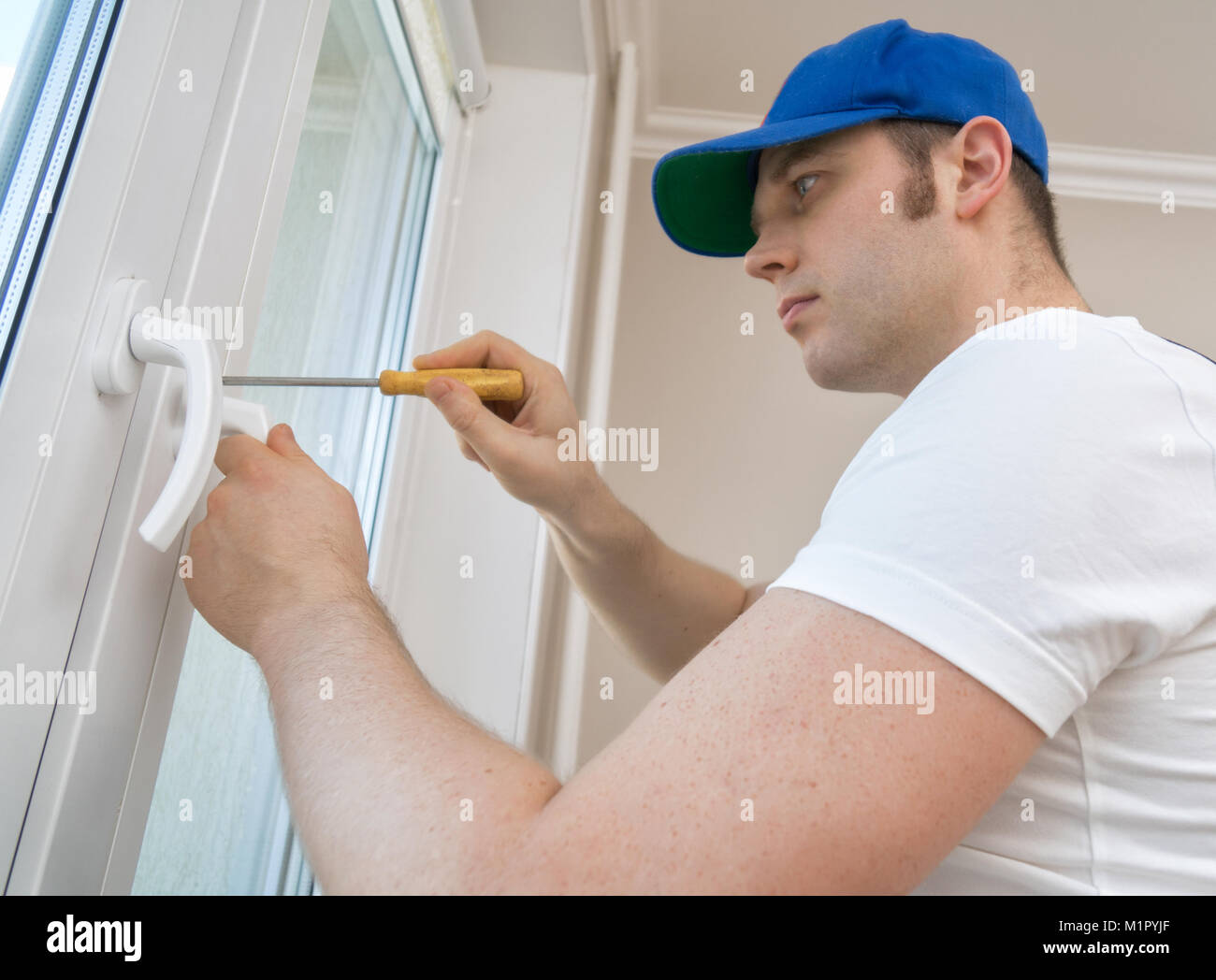 Professional handyman fixing window handle at home Stock Photo - Alamy