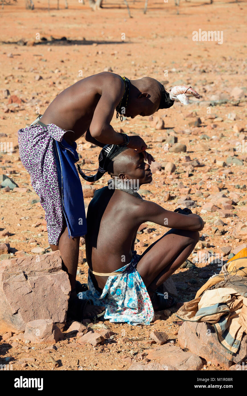 Himba man cuts the hair, Namibia, Himba Mann schneidet die Haare Stock Photo