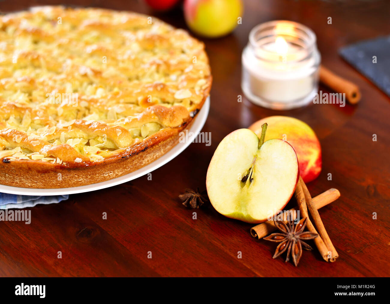 Fresh apple pie or fruitcake on a wooden table. Apple pie and fresh apples, cinnamon and star anise. Cake background. Stock Photo