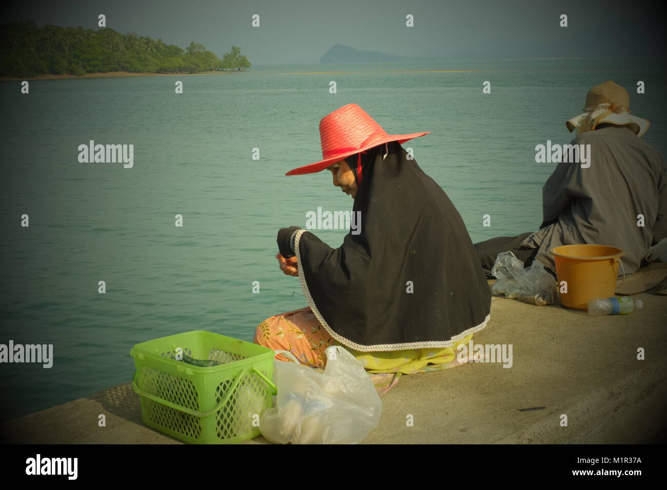 Two elderly women fishing in Koh Yao Yai, a Thai island in the Andaman Sea. 20-Jan-2018 Stock Photo