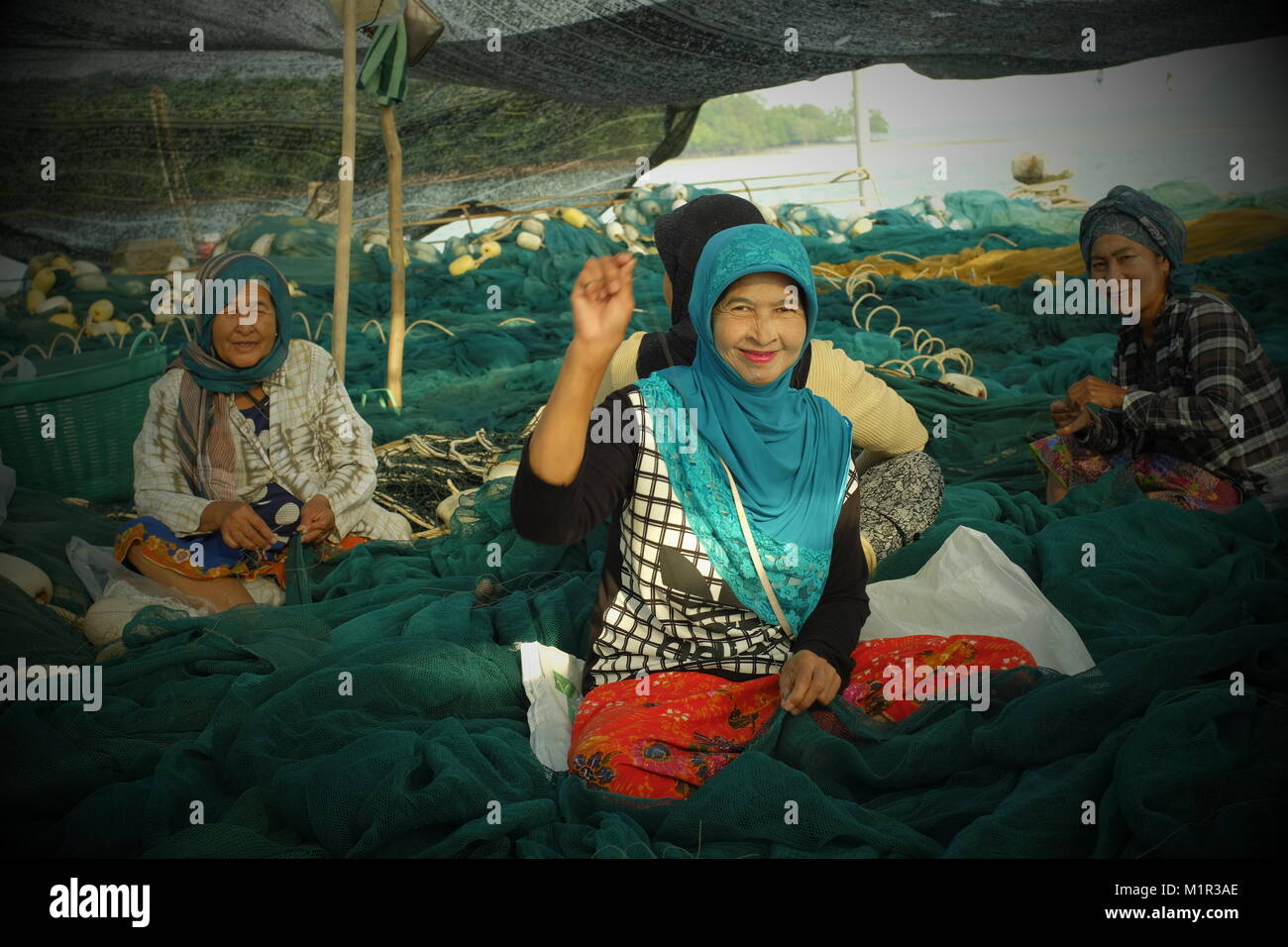 Local Muslim women weave the fishing net in koh Yao Yai, a Thai island in the Andaman Sea. 20-Jan-2018 Stock Photo