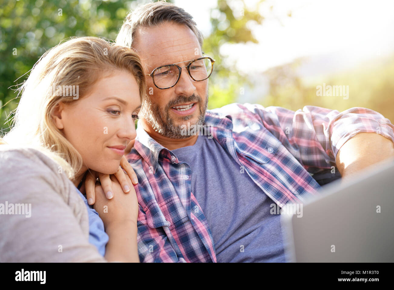 Portrait of mature couple relaxing in outdoor sofa Stock Photo