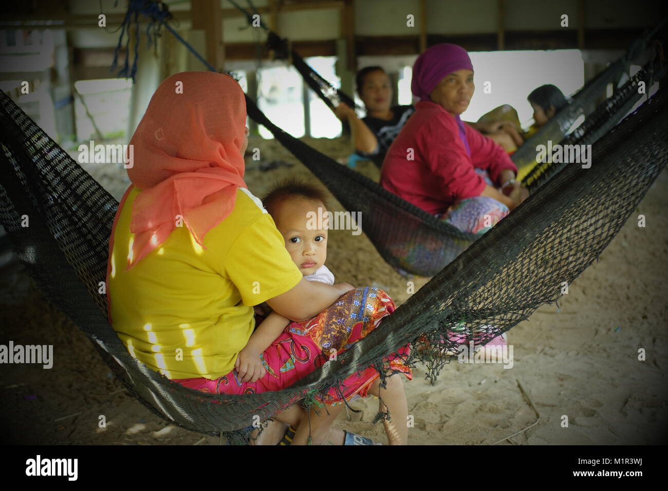 Local Muslim women rest in koh Yao Yai, a Thai island in the Andaman Sea. 20-Jan-2018 Stock Photo