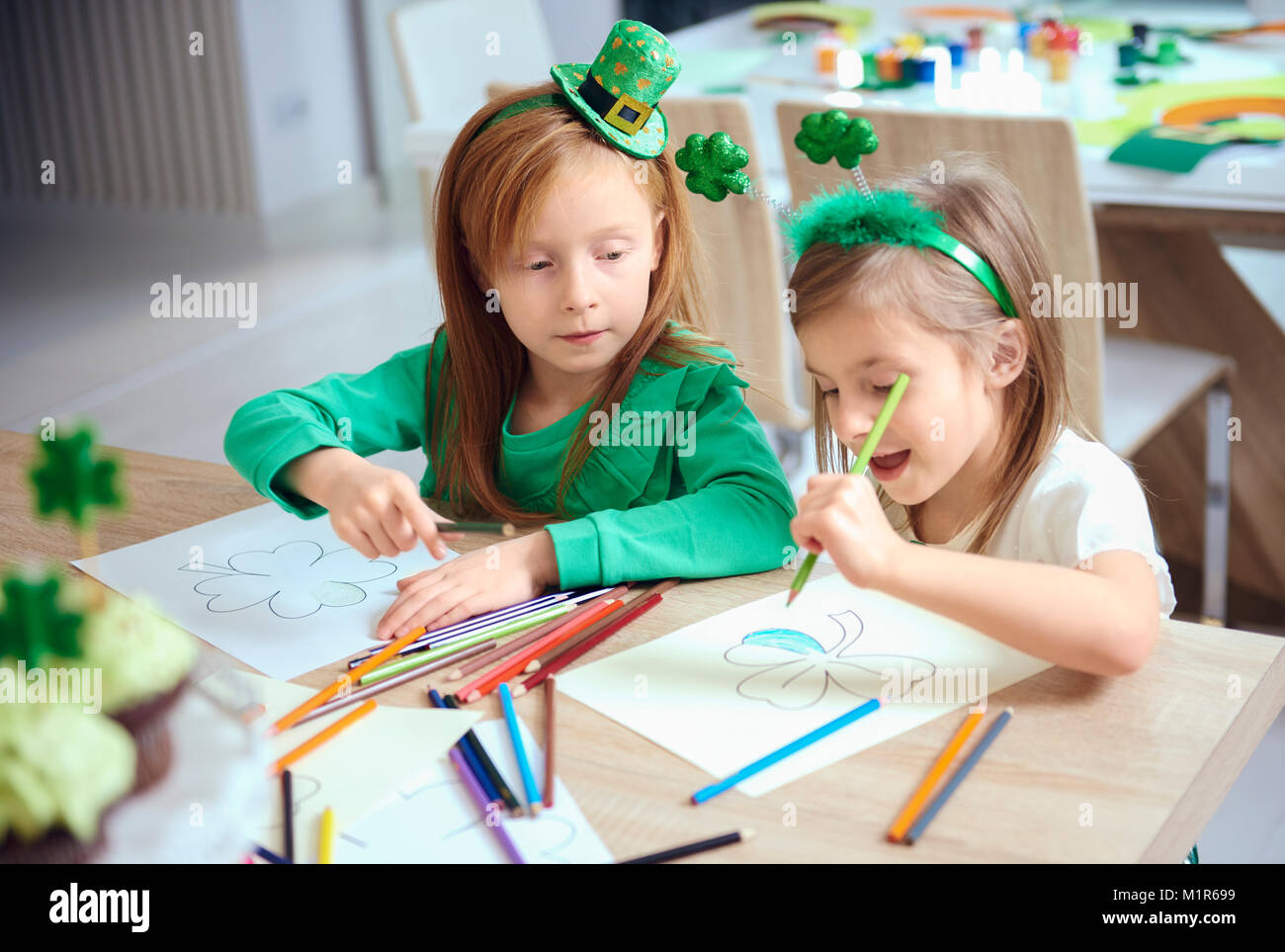 Cheerful siblings coloring different illustrations Stock Photo