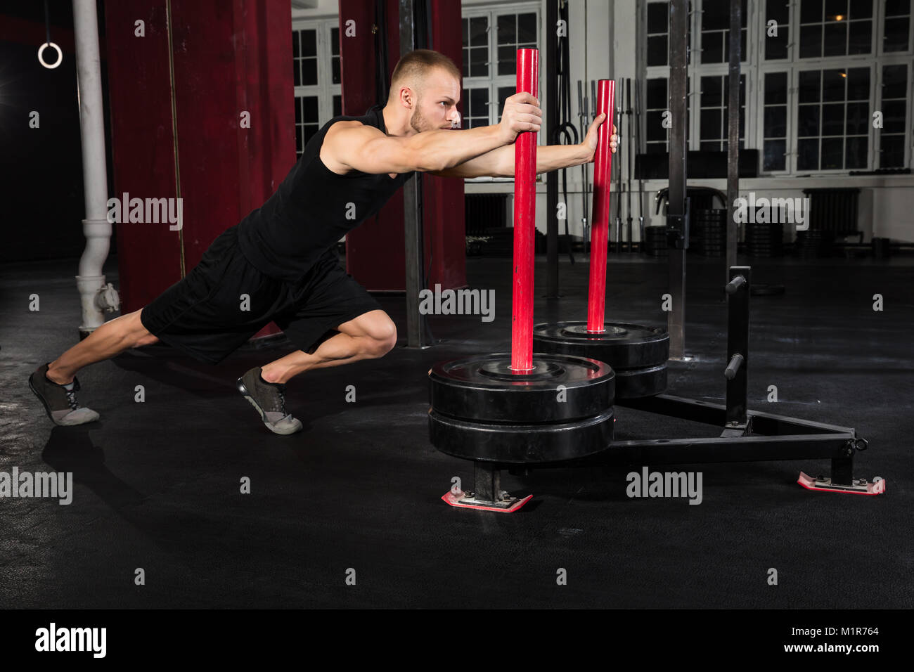 Young Athlete Man Getting Trained On Gym Equipment In Gym Stock Photo