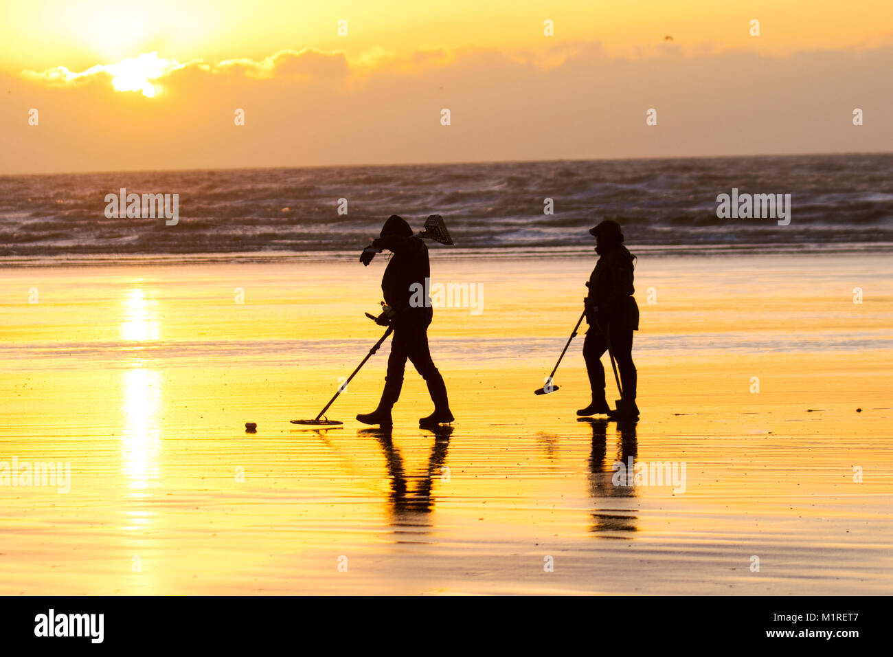 Two metal detectorists with a shovel and a spade scour Blackpool beach