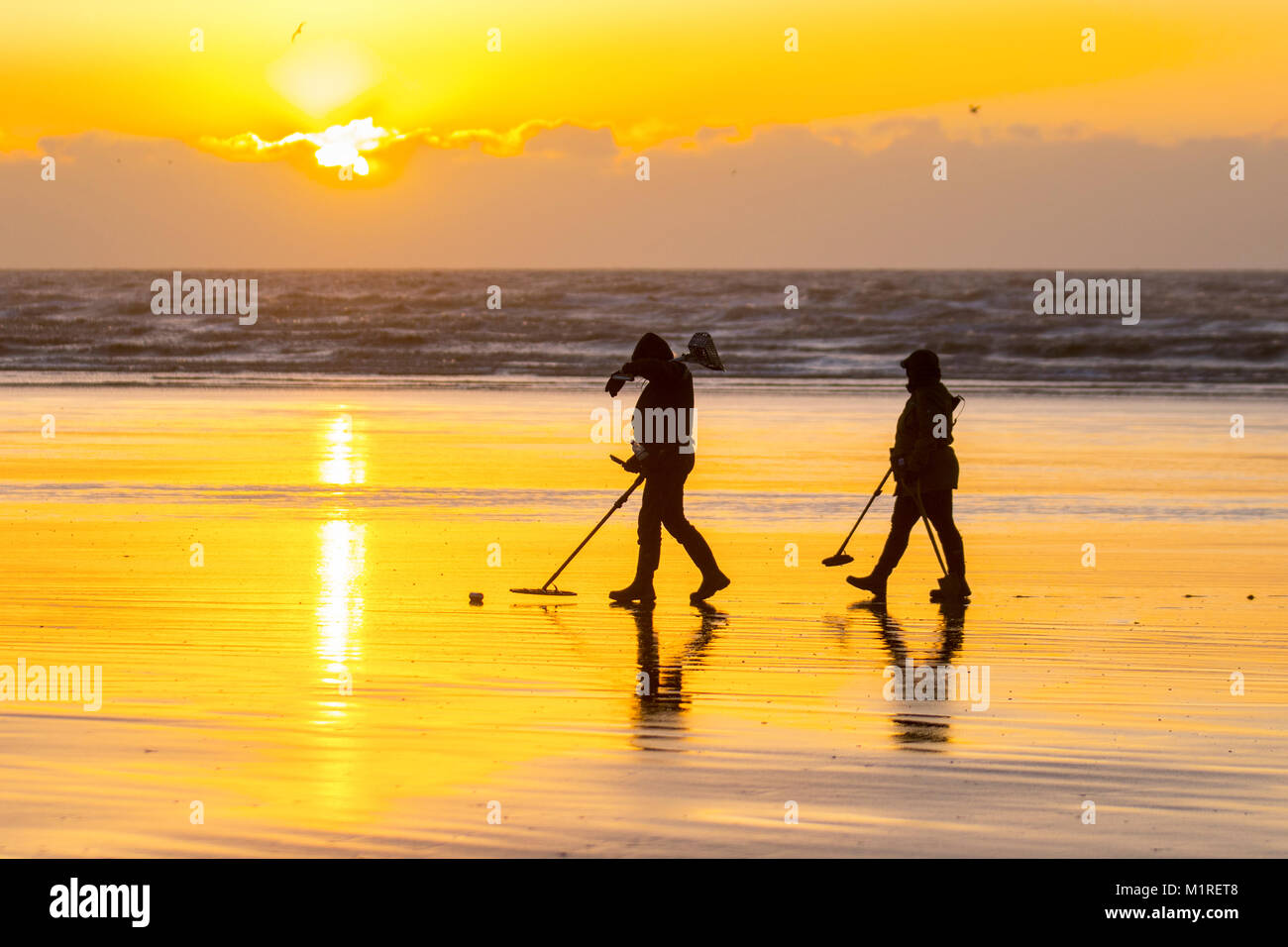 Two metal detectorists with a shovel and a spade scour Blackpool beach