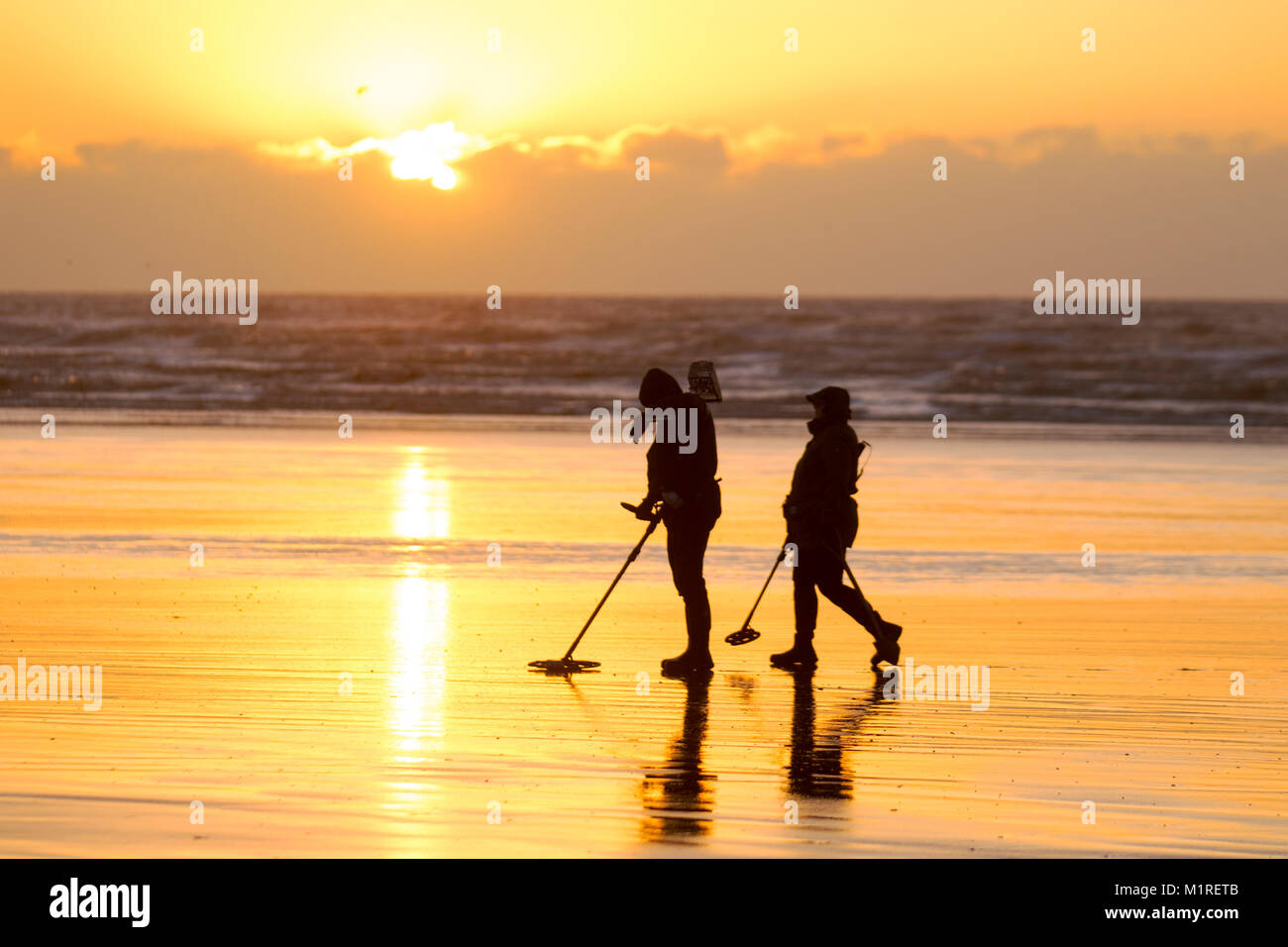 Two metal detectorists with a shovel and a spade scour Blackpool beach