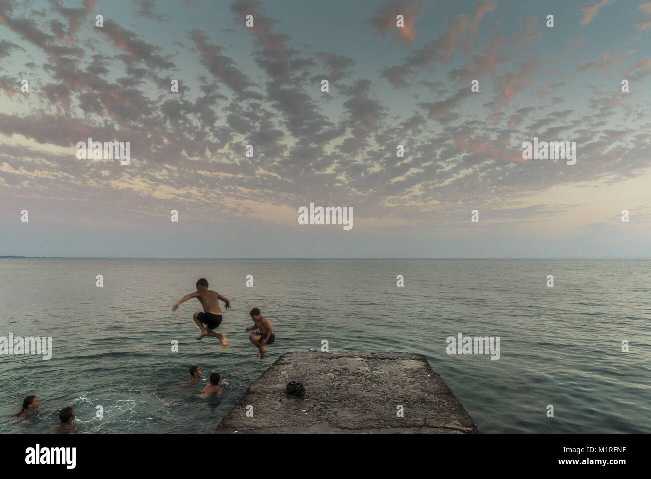 Sukhumi, Abkhazia, Georgia. 19th July, 2017. Russian kids jumping into the Black Sea after sunset in Sukhumi.Abkhazia is a partially recognized state located in north western Georgia. Back in the soviet era it was a vibrant area however after the soviet union collapsed in the early 90s the economy is fallen to its knees. In 2008 Russia sent its military to support the separatist to gain independence from Georgia. Credit: Maurice Wolf/SOPA/ZUMA Wire/Alamy Live News Stock Photo