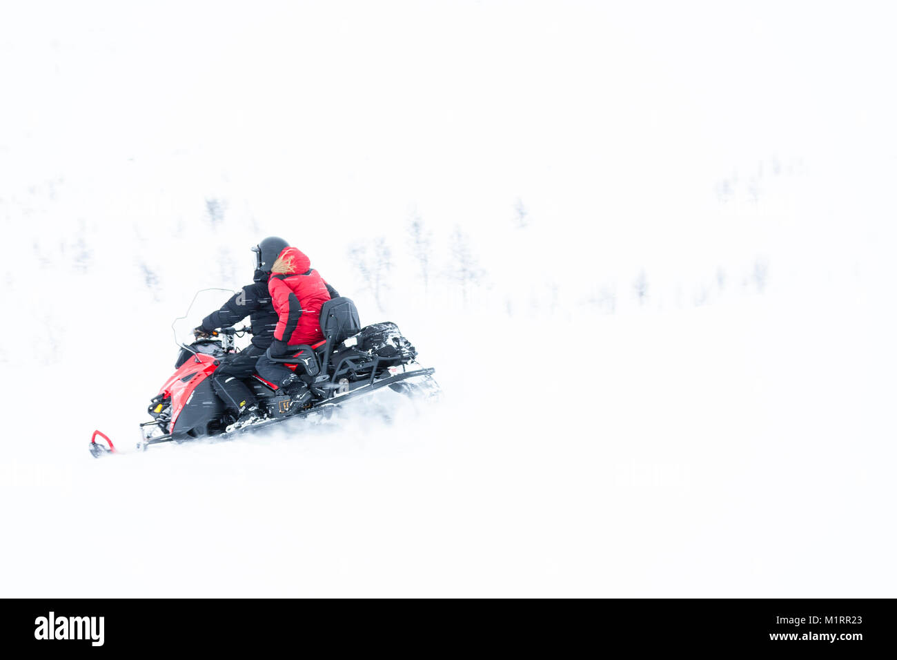 Skibotn, Norway. Kjetil Skogli and Annika Summerson riding snowmobile. Stock Photo