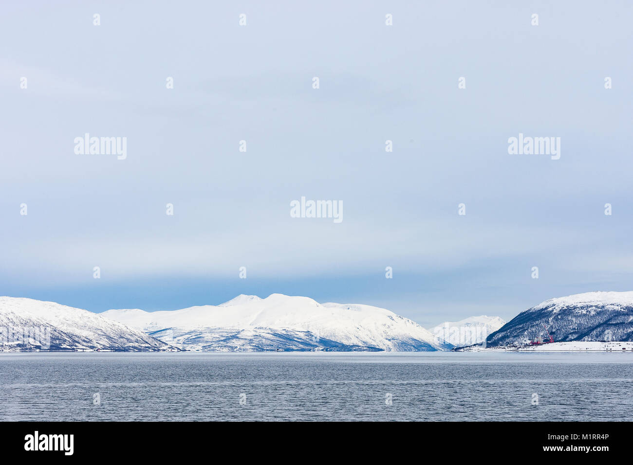 Norway. Dramatic Norwegian mountains covered in snow above fjord. Stock Photo