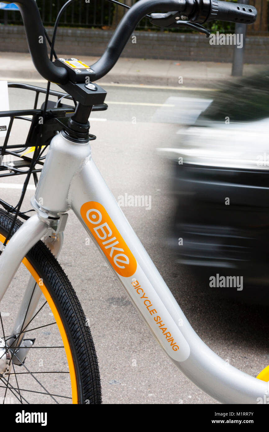 LONDON, ENGLAND. Traffic passing an unused Obike in Fulham following the service's troubled launch in London. Stock Photo