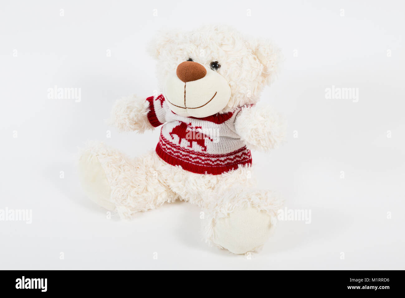 London, UK. Stuffed child's teddy bear wearing white and red knitted jumper. Stock Photo