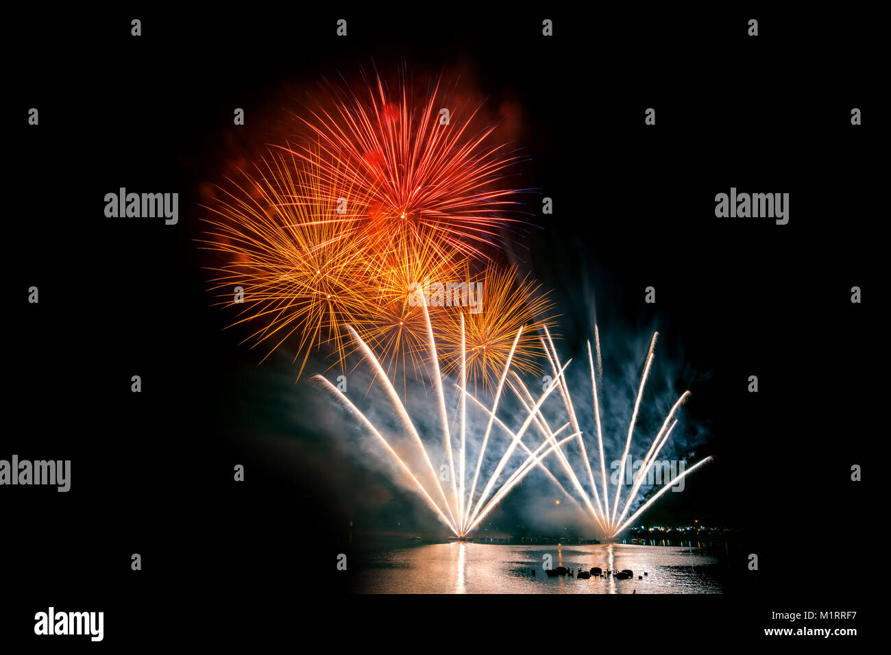 Bright and colorful fireworks against a black night sky.Fireworks for new year. Beautiful colorful fireworks display on the urban lake for celebration Stock Photo