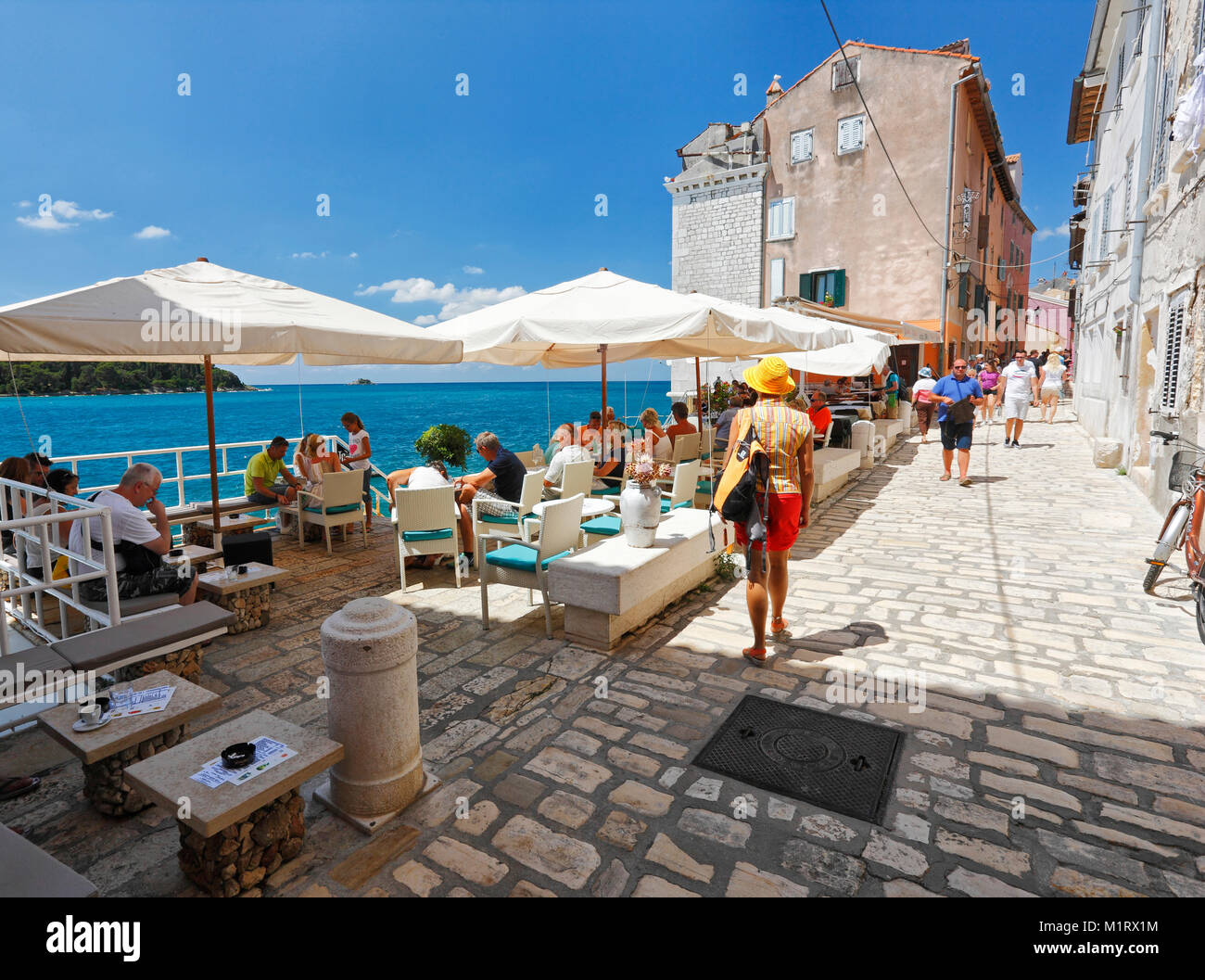 Tourists enjoying free time in caffee bar in old town Rovinj, Croatia ...