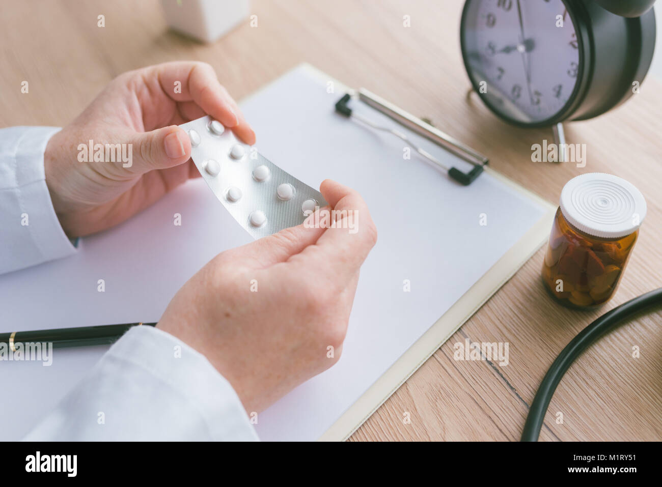 Female doctor holding unlabeled generic tablets and medication, generic