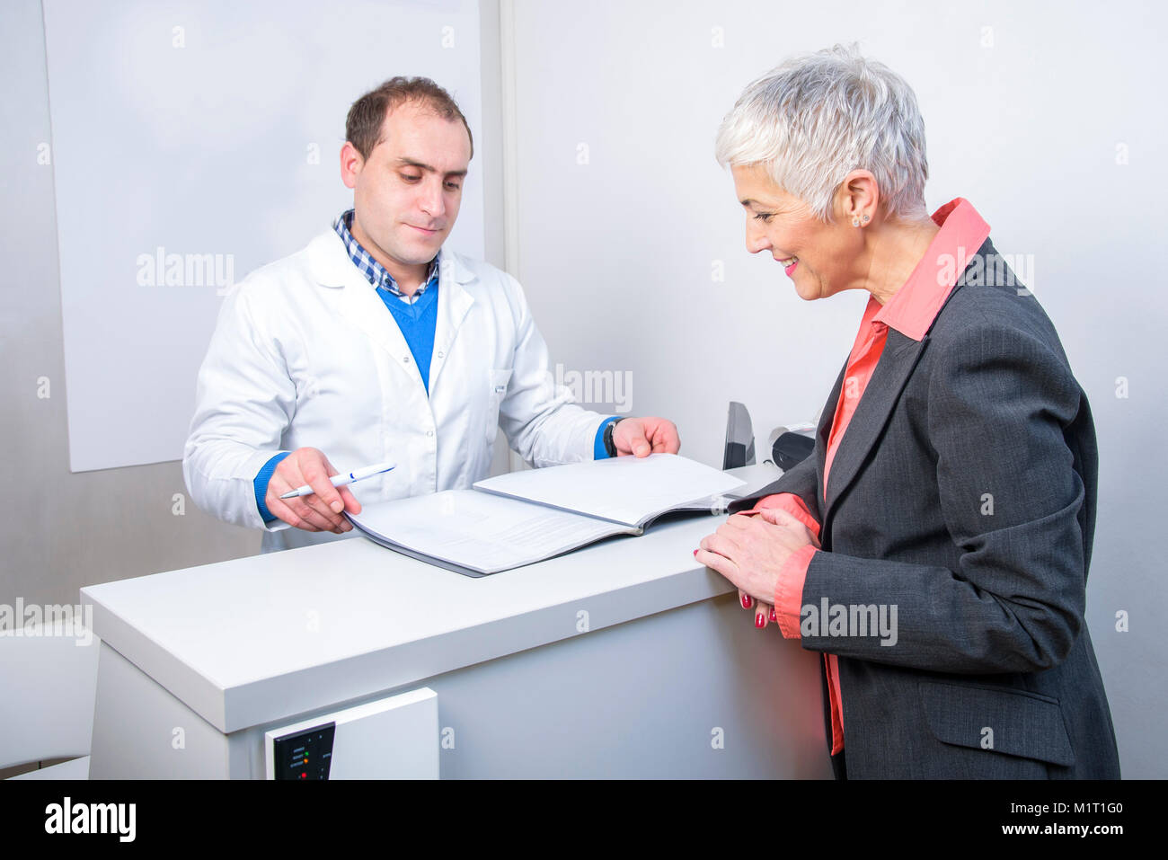 Happy older lady paying her medical bill Stock Photo