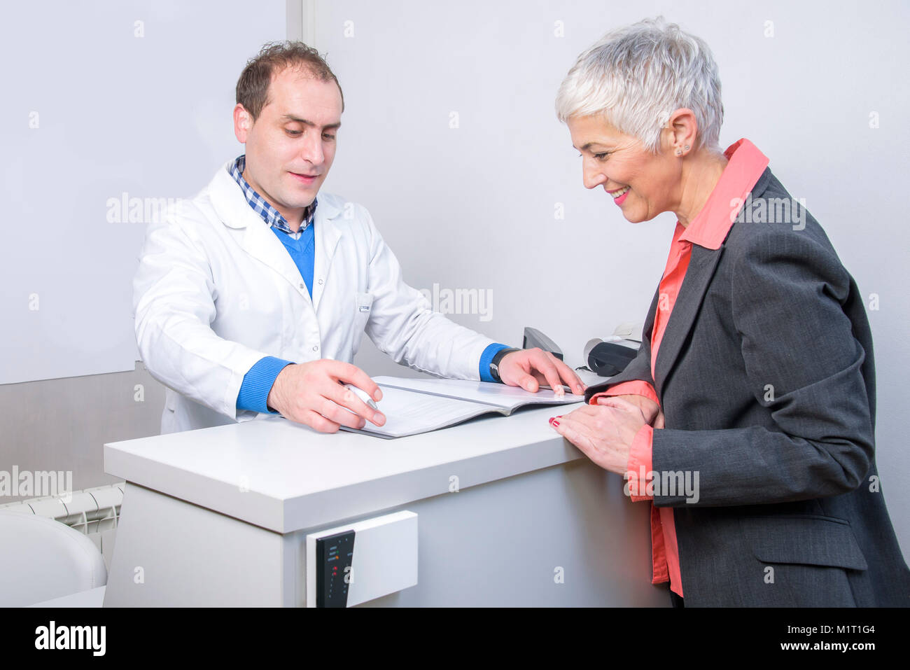 Happy older lady paying her medical bill Stock Photo