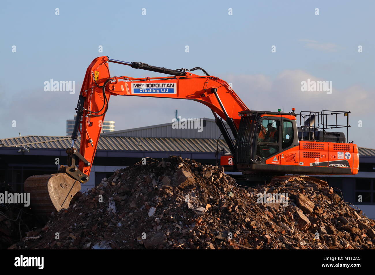 A Doosan excavator for Metropolitan Crushing Ltd heaps up rubble, ready to go into a crusher on the Thyssenkrupp site which closed down due to floods. Stock Photo