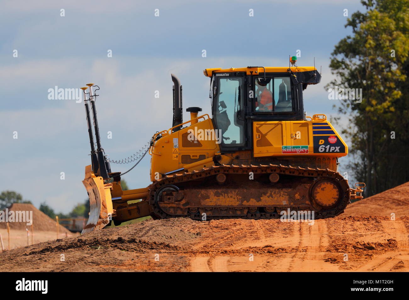 A Komatsu Dozer awaits materials to arrive so they can be pushed out to