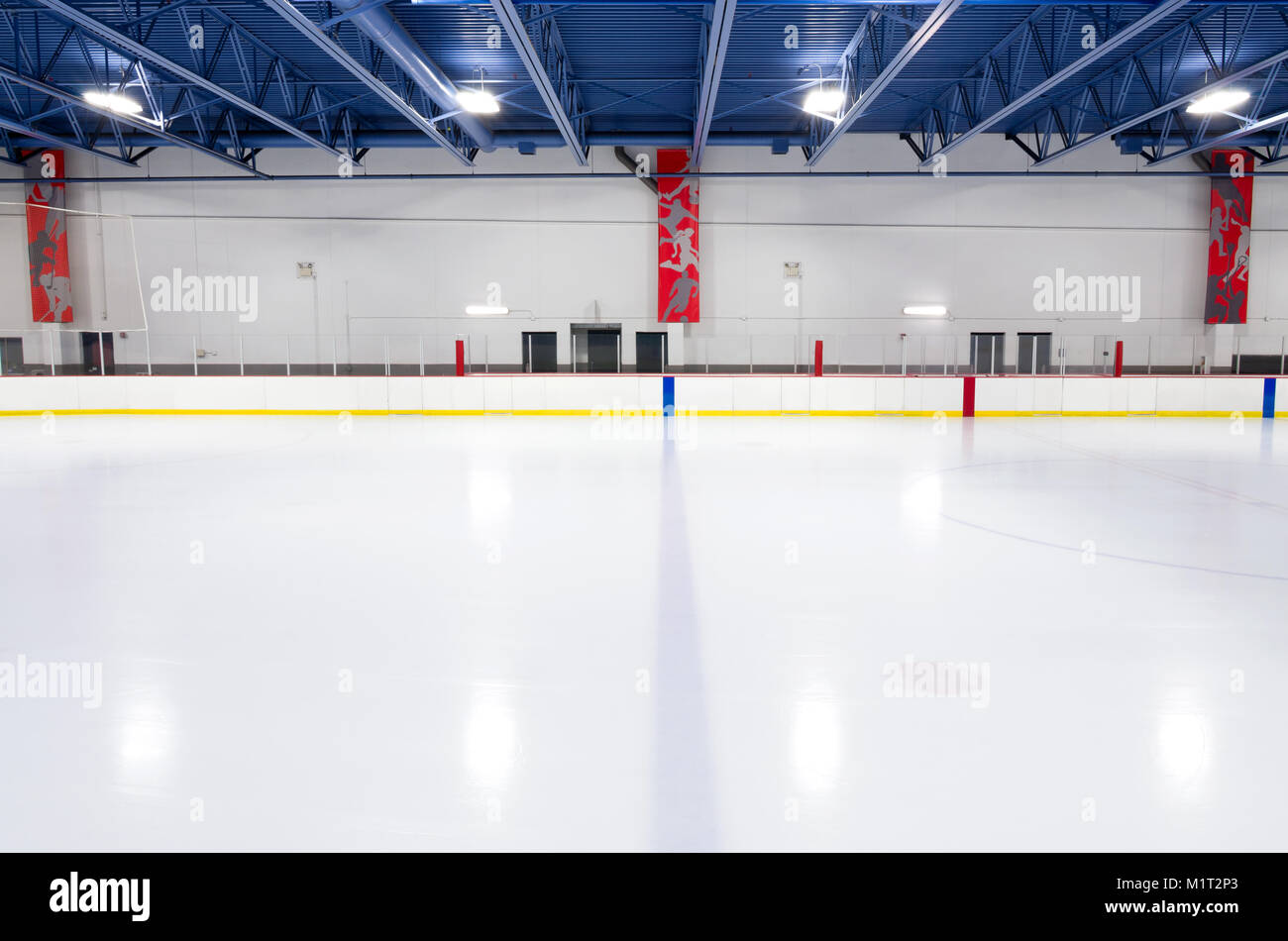 well lit interior of hockey rink at center ice along blue line Stock Photo