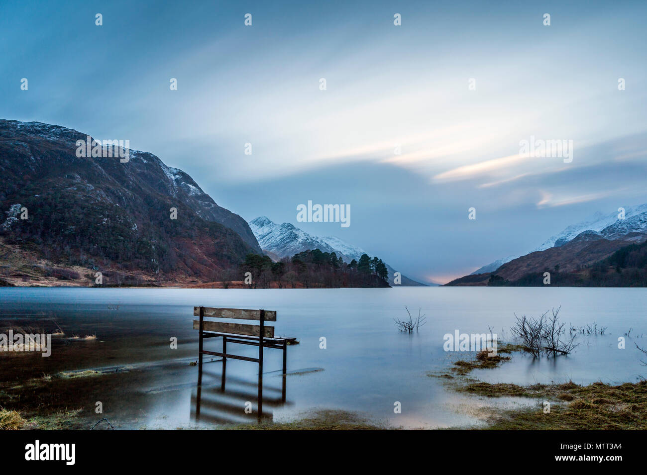 The water levels at Glenfinnan Bay, on Loch Shiel, are much higher than usual, and this bench has become waterlogged. Stock Photo