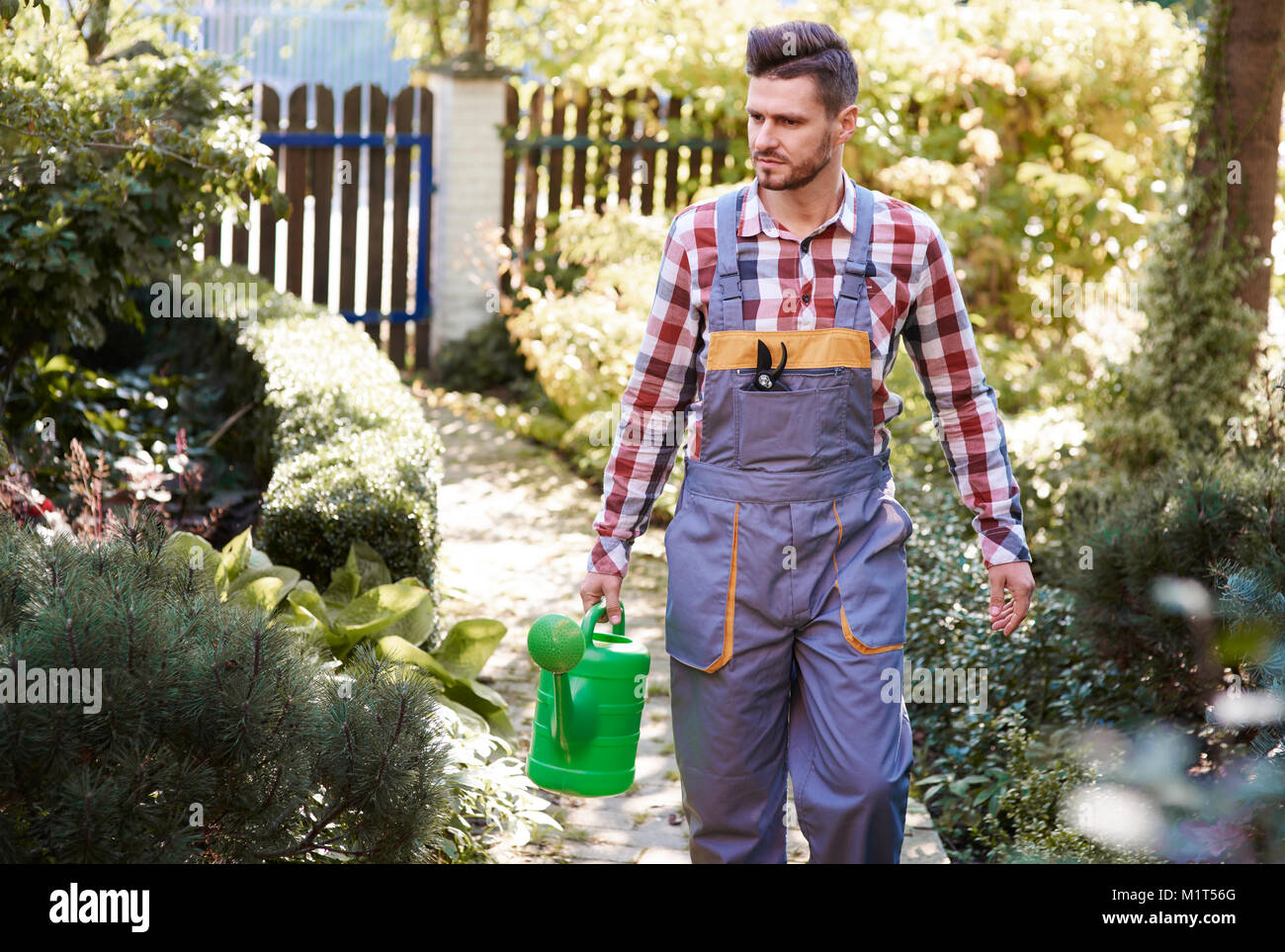Man with  watering can at garden Stock Photo