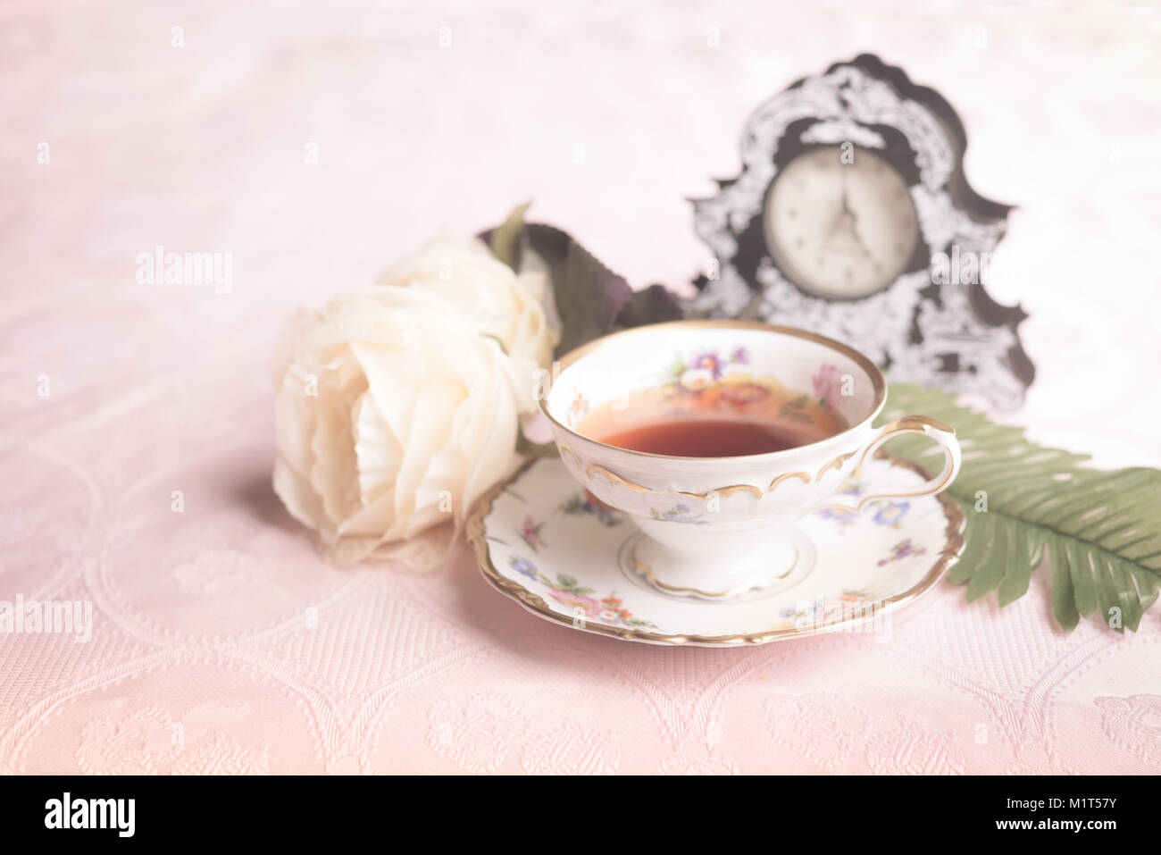 Old antique cup of tea on pink table cloth Stock Photo