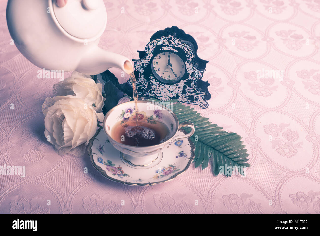 Old antique cup of tea on pink table cloth Stock Photo