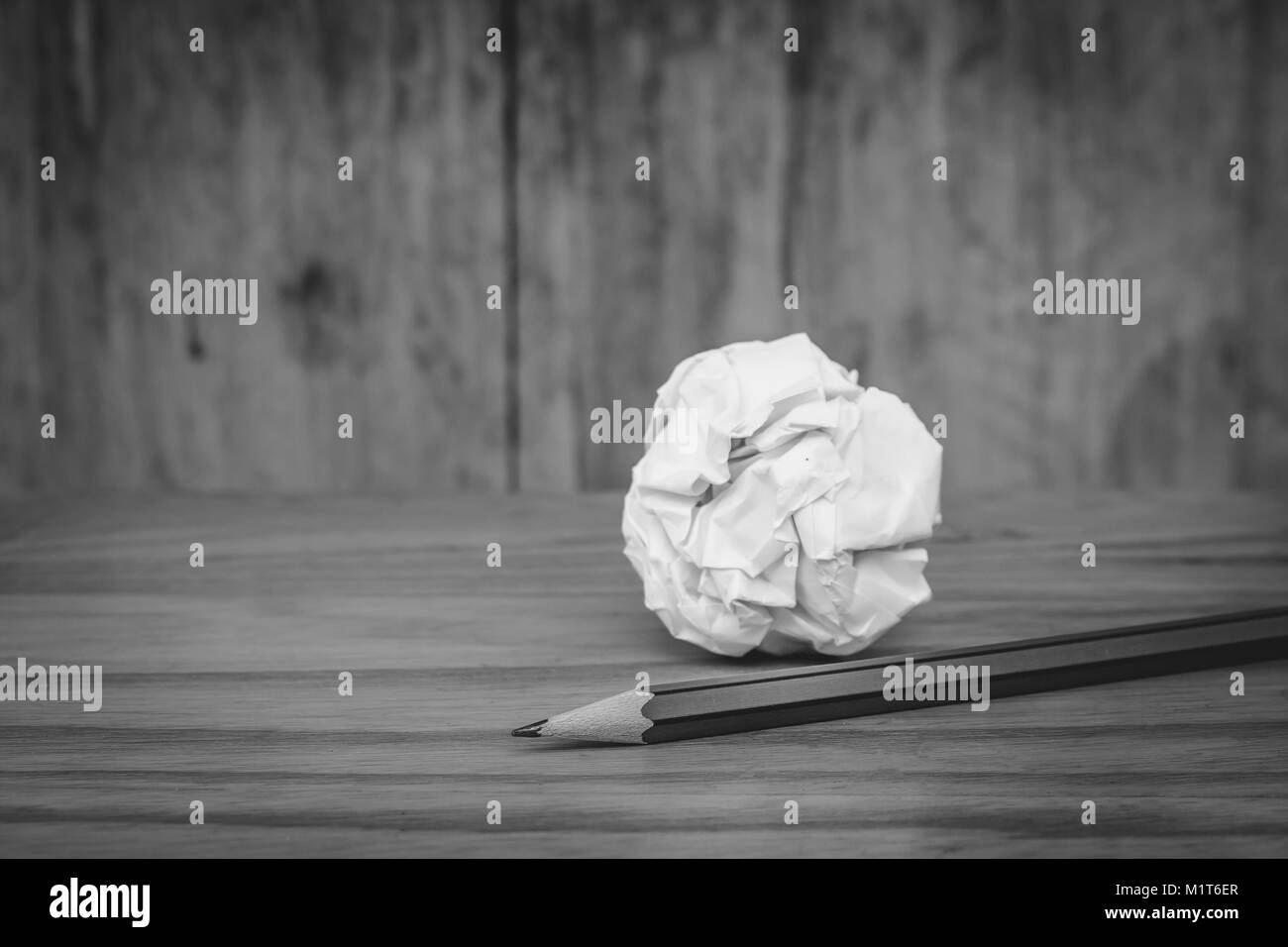 Business Creative and Idea Concept Top view of three pencil with white crumpled paper ball put on wooden floor in black and white image. Stock Photo
