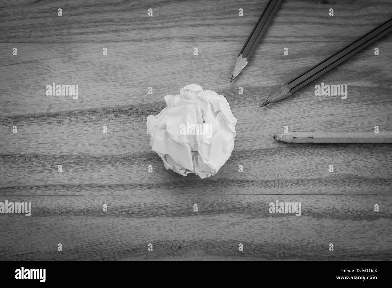 Business Creative and Idea Concept Top view of three pencil with white crumpled paper ball put on wooden floor in black and white image. Stock Photo
