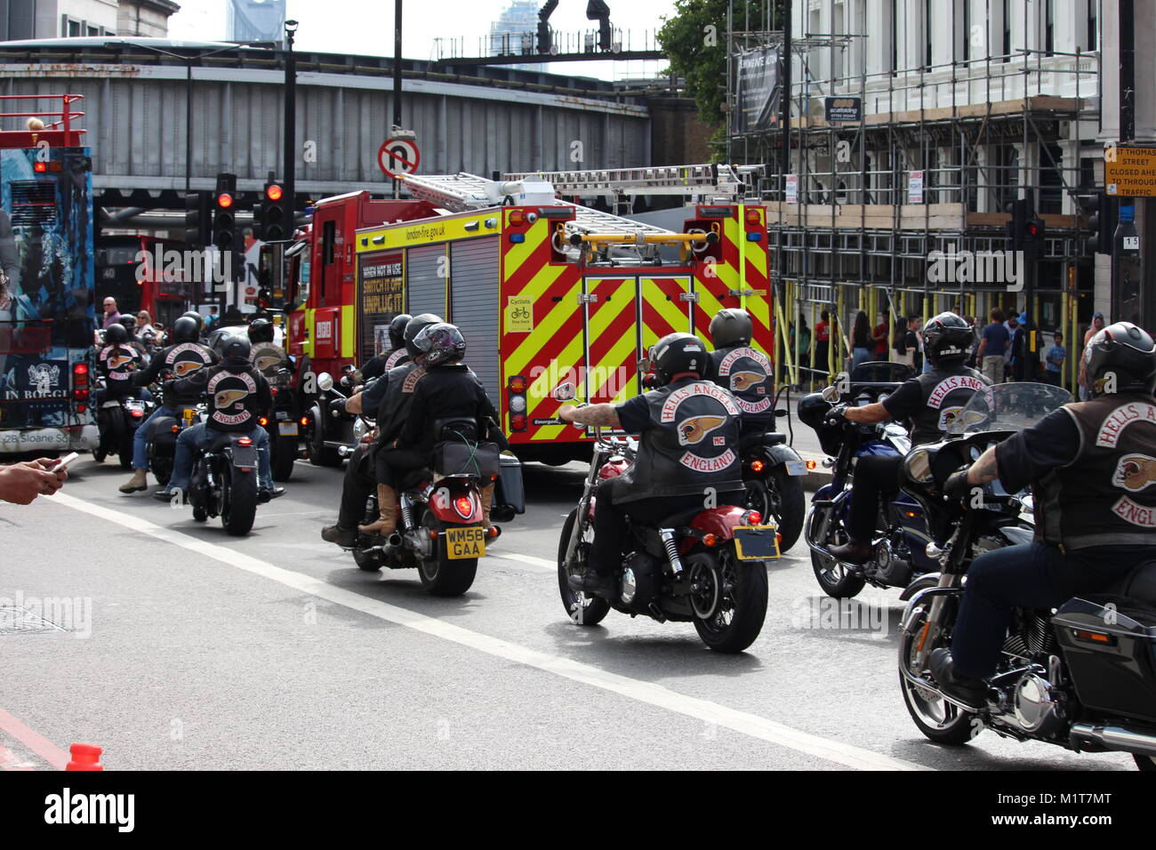 London, United Kingdom - August 26 2017: A group of Hell's Angels motor bikers in London queue at traffic lights behind a fire engine. Stock Photo