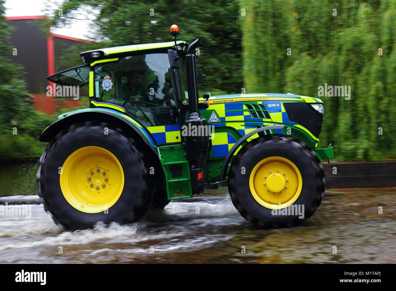 A police tractor drives through a river ford in Ripon during an annual