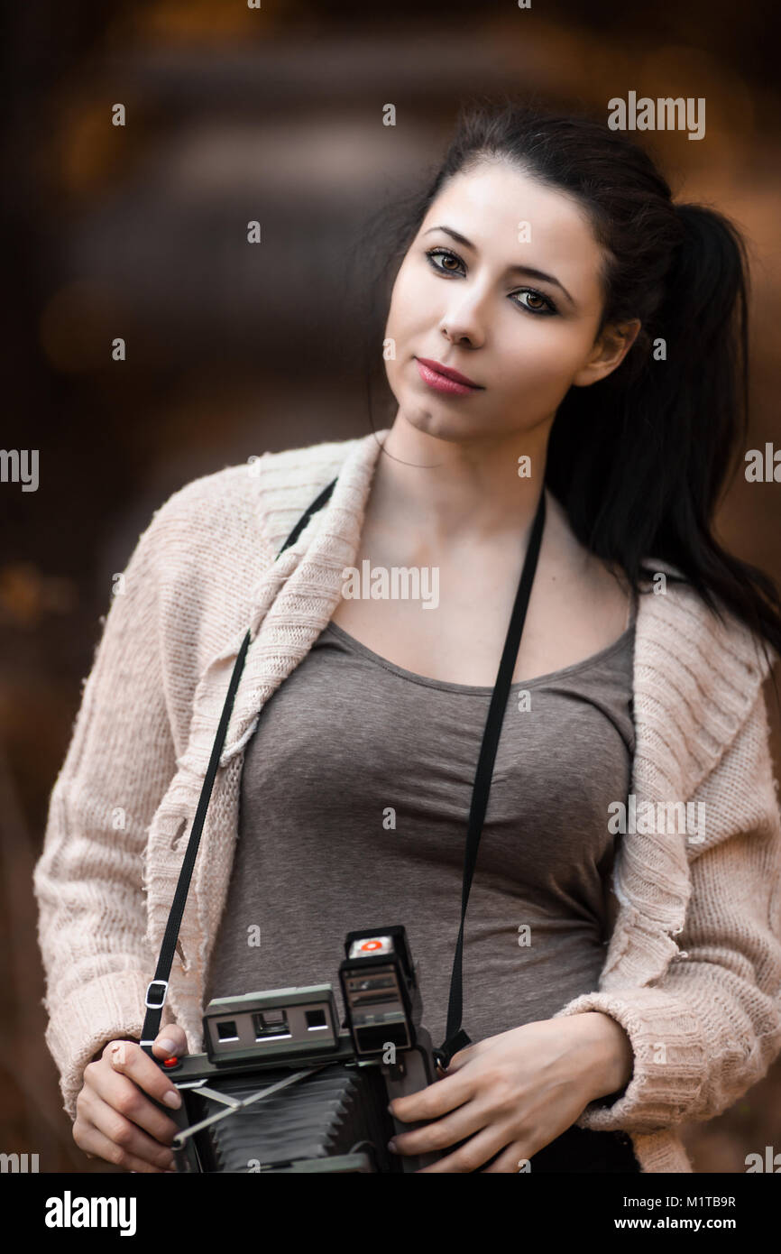 Beautiful Young Woman Holding Vintage Old Camera, classic retro style photograph Stock Photo
