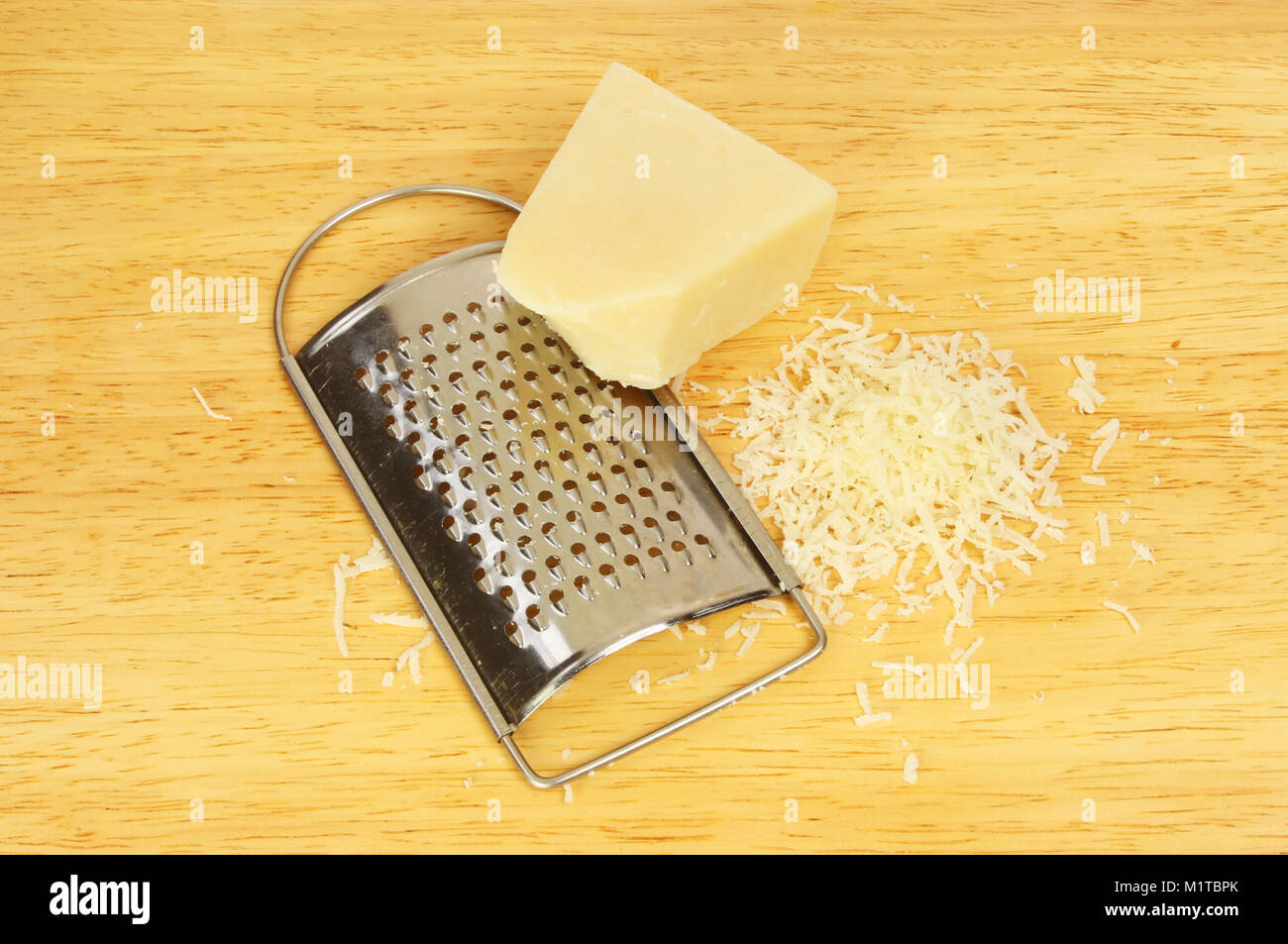 https://c8.alamy.com/comp/M1TBPK/parmesan-cheese-and-grater-on-a-wooden-chopping-board-M1TBPK.jpg
