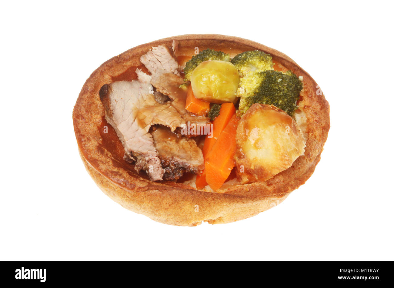 Roast beef dinner in a giant Yorkshire pudding isolated against white Stock Photo