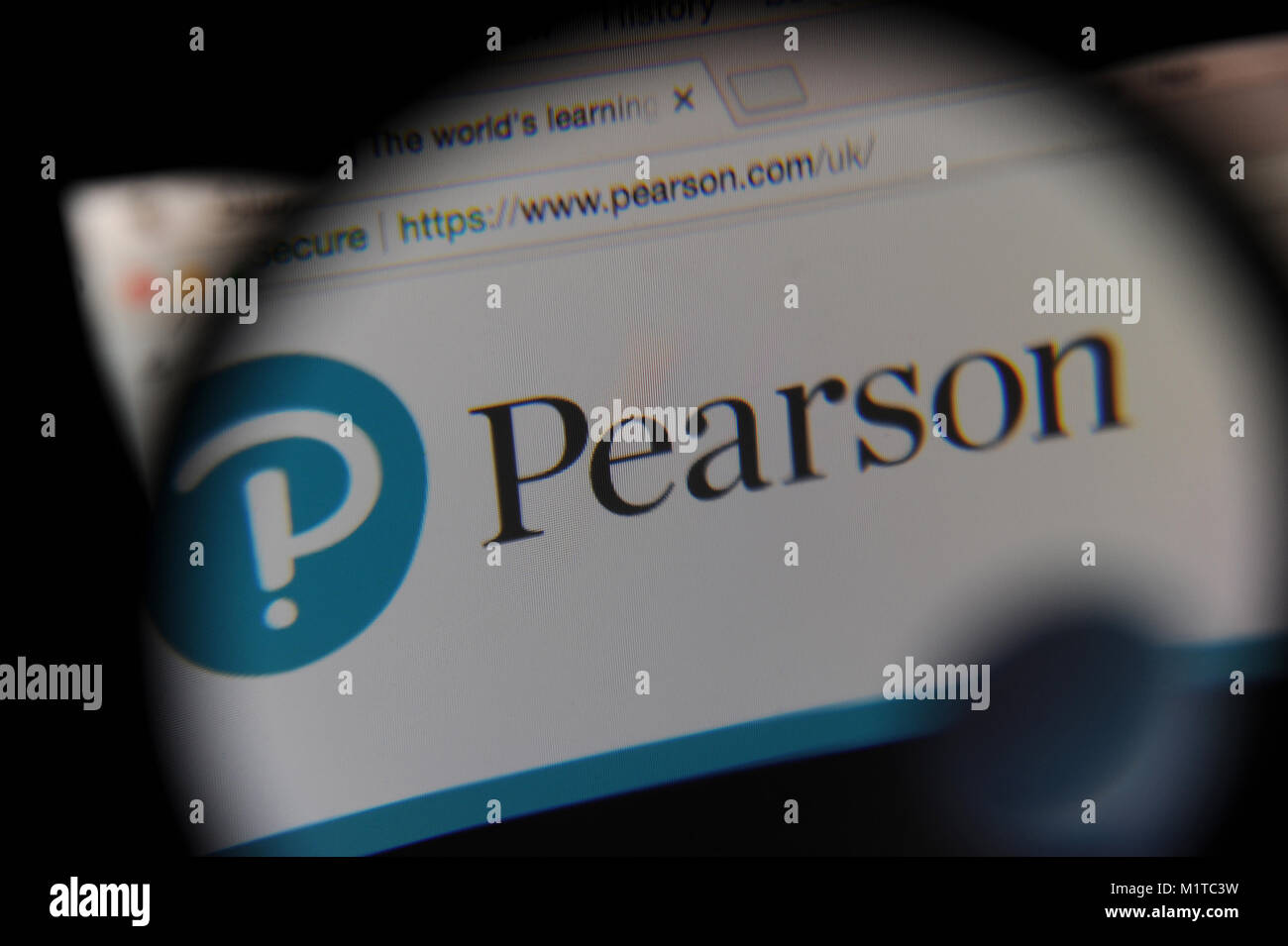 The Pearson website seen through a magnifying glass Stock Photo Alamy