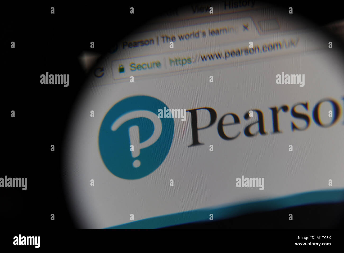 The Pearson website seen through a magnifying glass Stock Photo Alamy