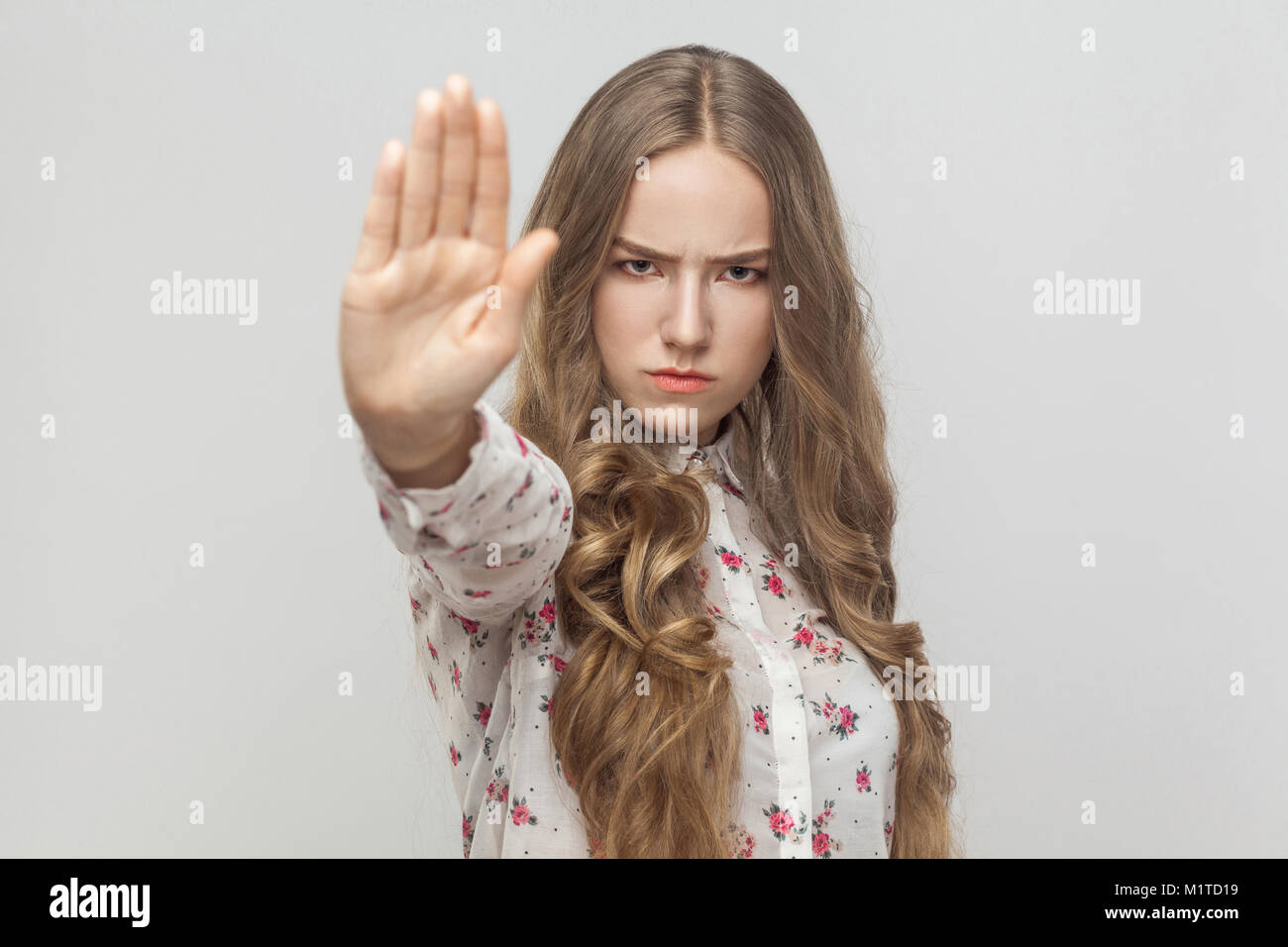 Stop! Rage young woman showing no sign. Studio shot, gray background ...