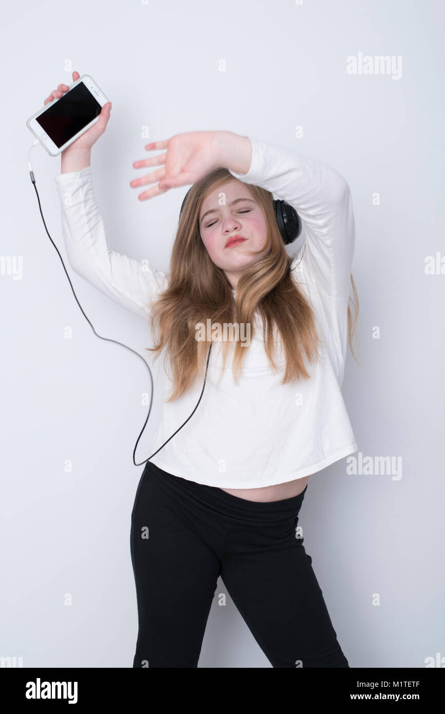 Girl dancing with eyes closed and hands over head while listening to