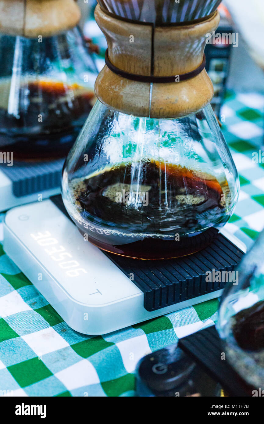 Pour over coffee drips in artisan glass brewers sitting on electronic