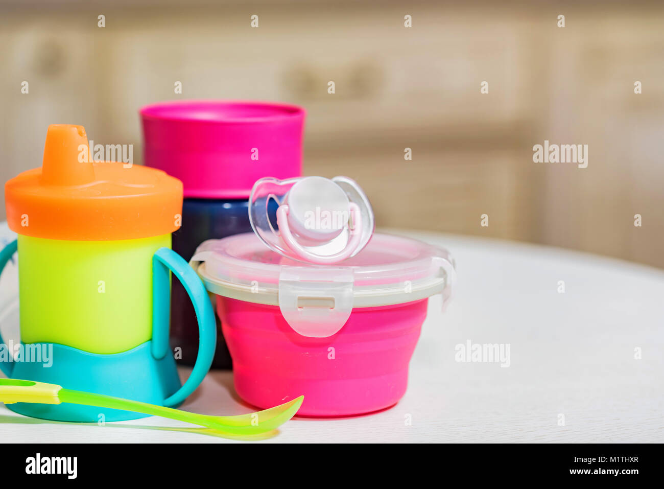 Bright plastic baby dishes on table Stock Photo Alamy