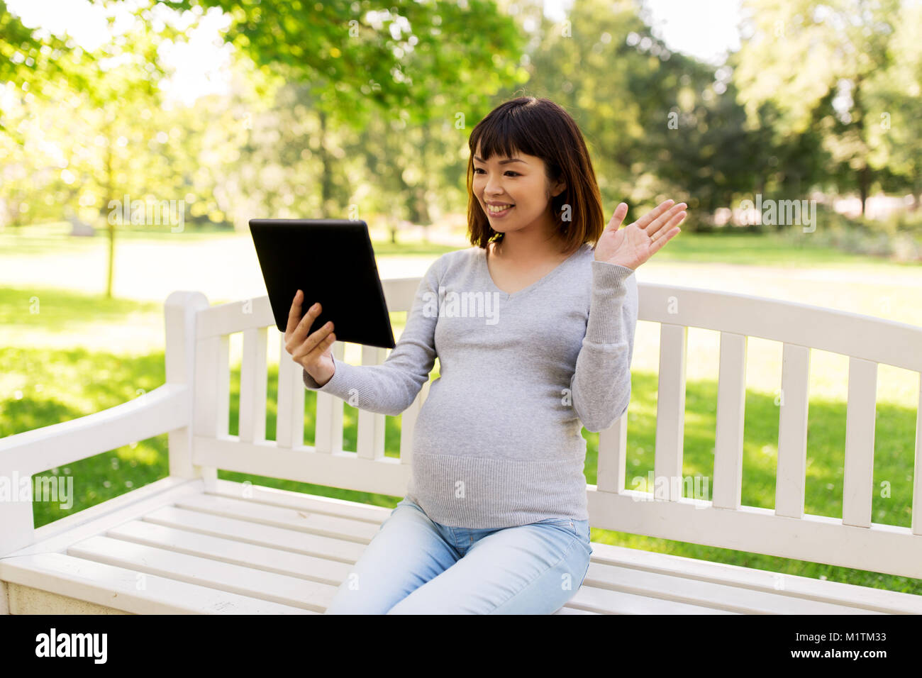happy pregnant asian woman with tablet pc at park Stock Photo - Alamy
