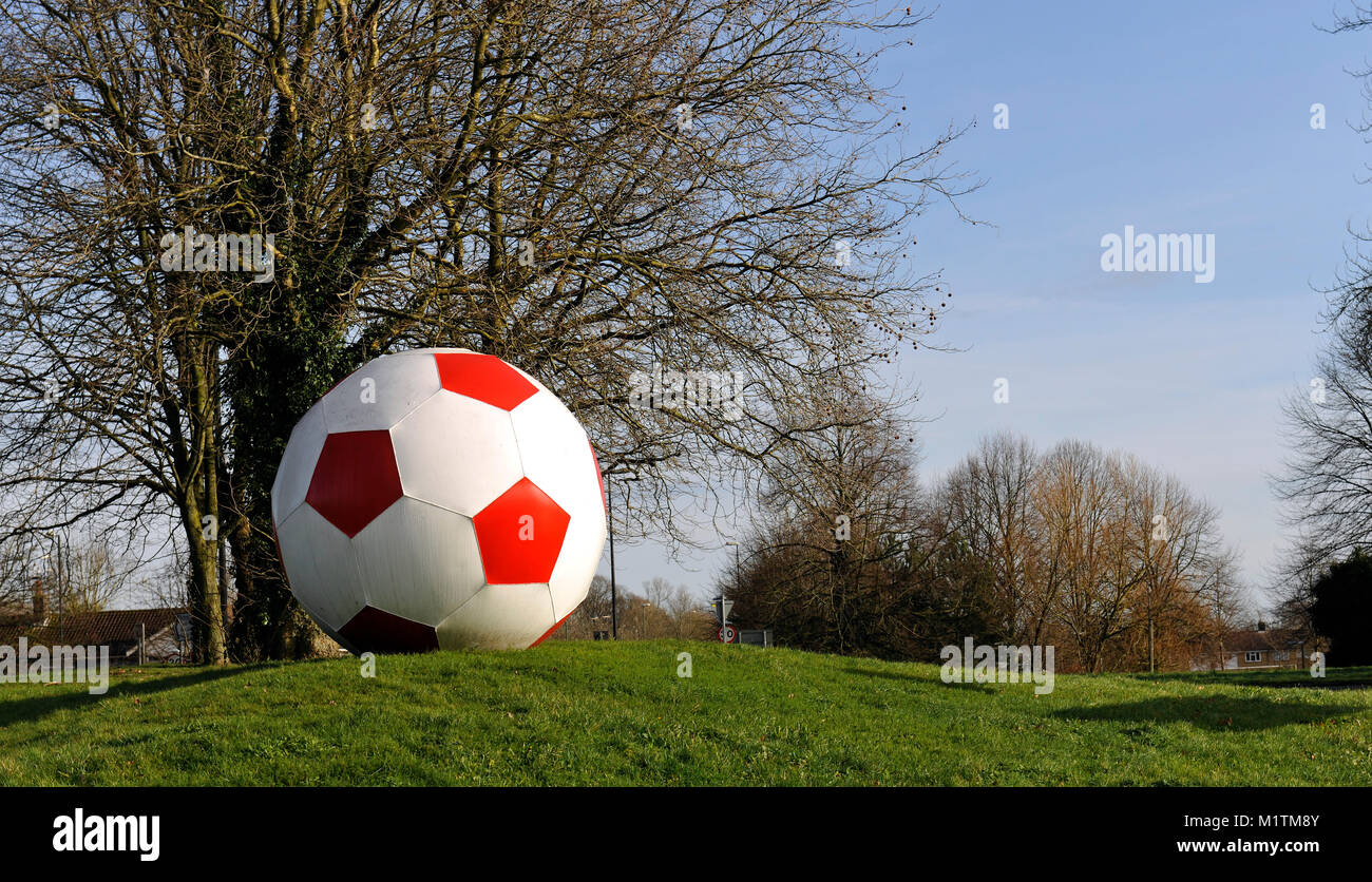 Giant football on street roundabout besides Crawley Town Football Stadium, Crawley, West Sussex, England, UK. Stock Photo