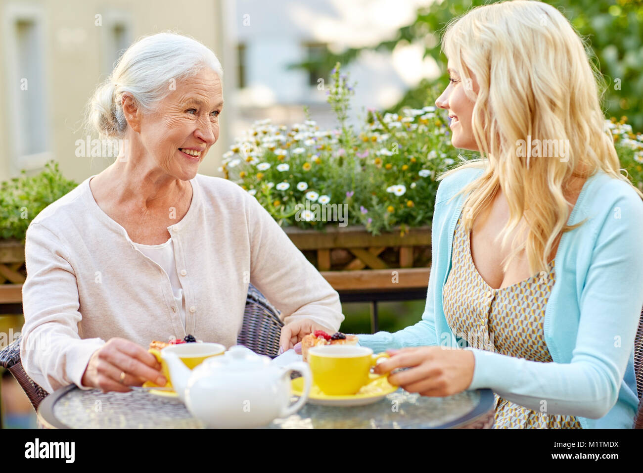 Daughter With Senior Mother Drinking Tea At Cafe Stock Photo Alamy