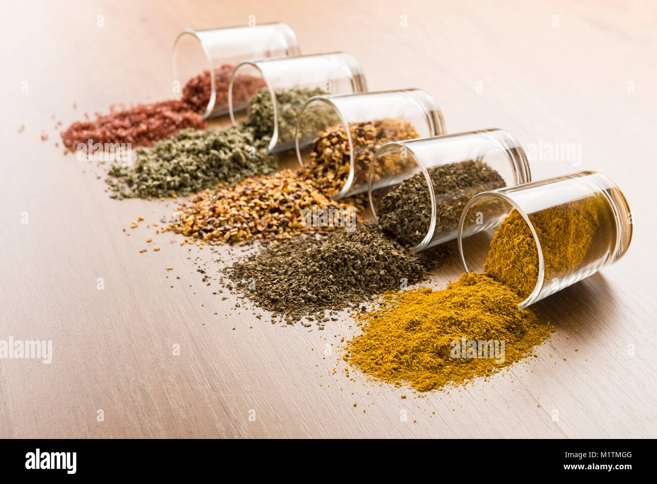 glass jars with various spices on wooden table Stock Photo