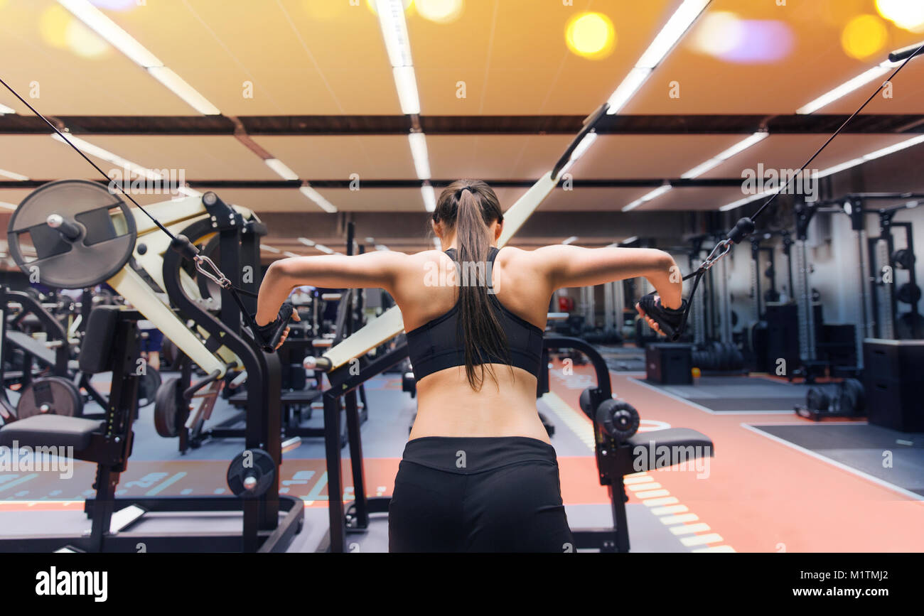 woman flexing muscles on cable machine in gym Stock Photo Alamy
