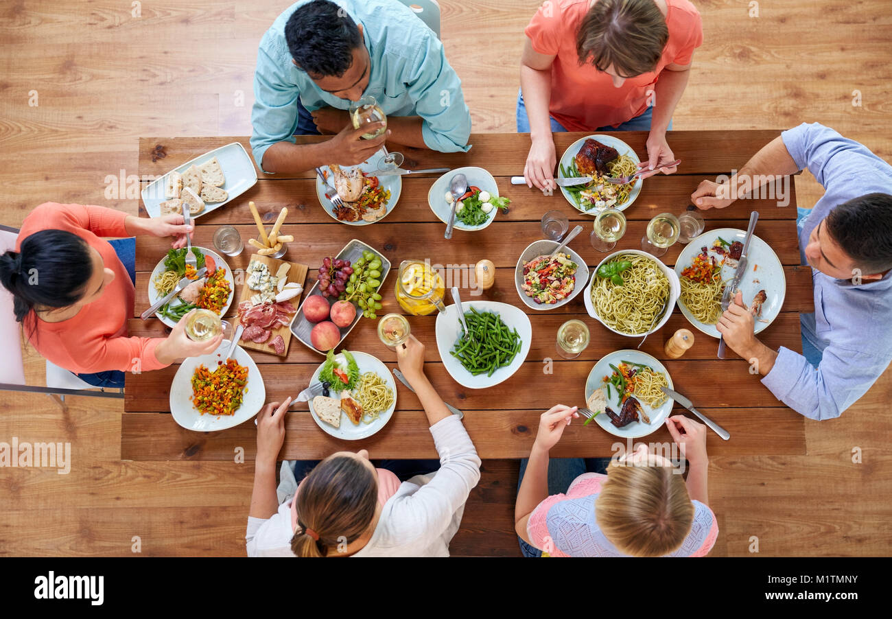 group of people eating at table with food Stock Photo - Alamy