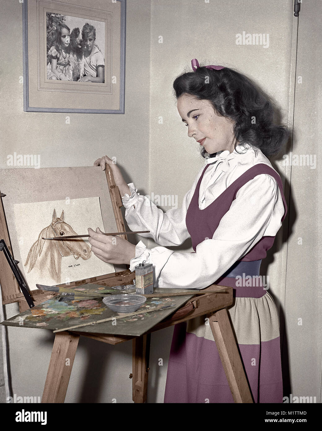 Elizabeth Taylor painting Man-O-War, circa 1944. Photo of Her and brother Howard on the wall. Stock Photo